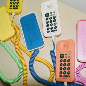A yellow, white, blue and orange Tin Can WiFi phones are shown on a table
