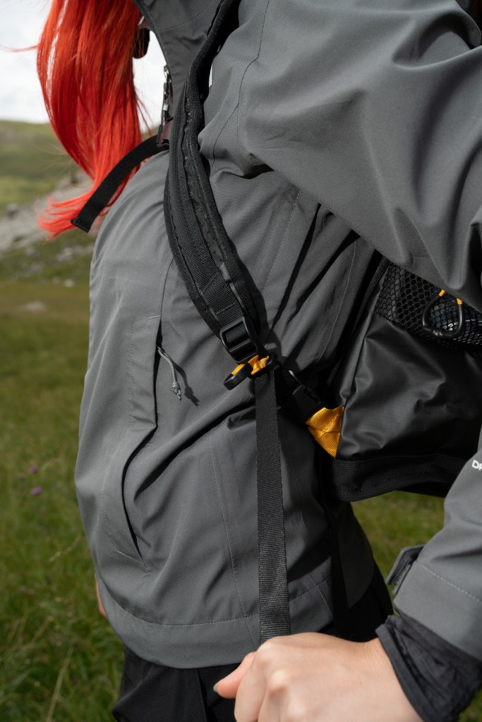 A detail of a woman's torso while wearing The North Face Universal Daypack, with her hands pulling down on the straps.