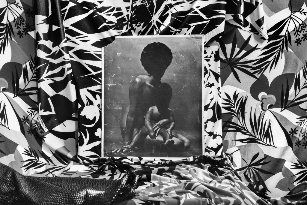 A black-and-white photo print of a woman with her baby, resting on a black-and-white graphic print fabric.