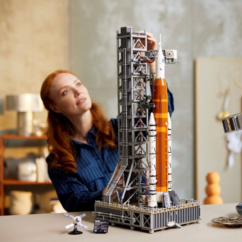 A woman assembles Lego's NASA Artemis Space Launch System model