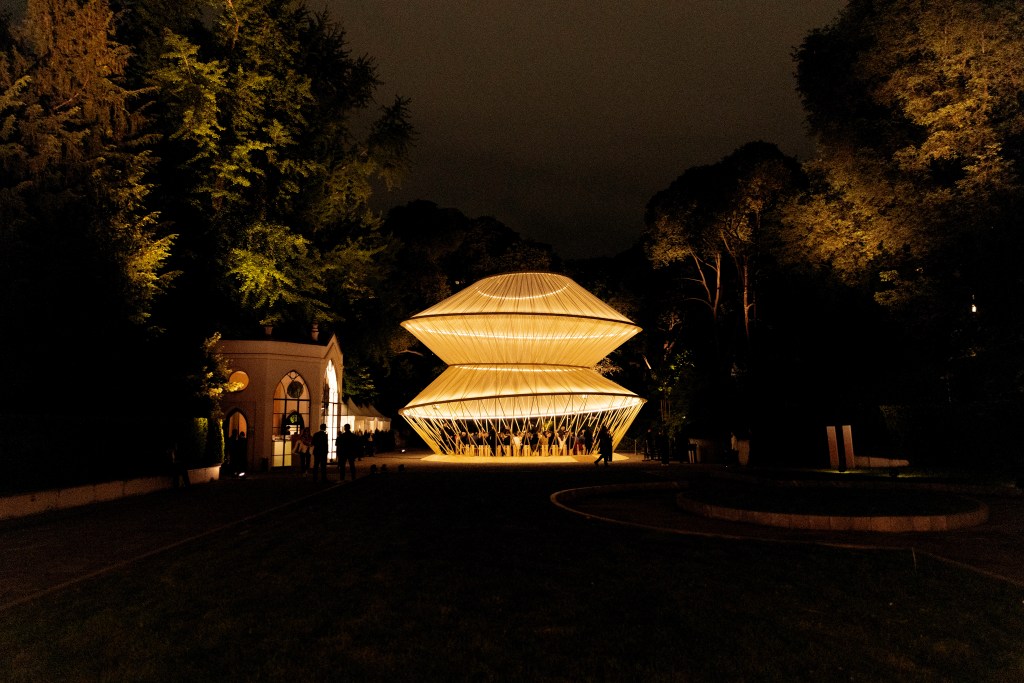 A night view of a deconstructed yurt in The Garden Pavilion, lit up in the dark.