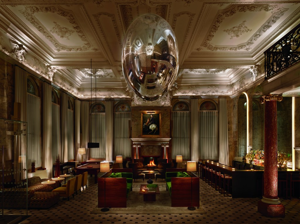 A large silver orb by contemporary lighting designer Ingo Maurer hangs in the lobby of the London EDITION hotel.