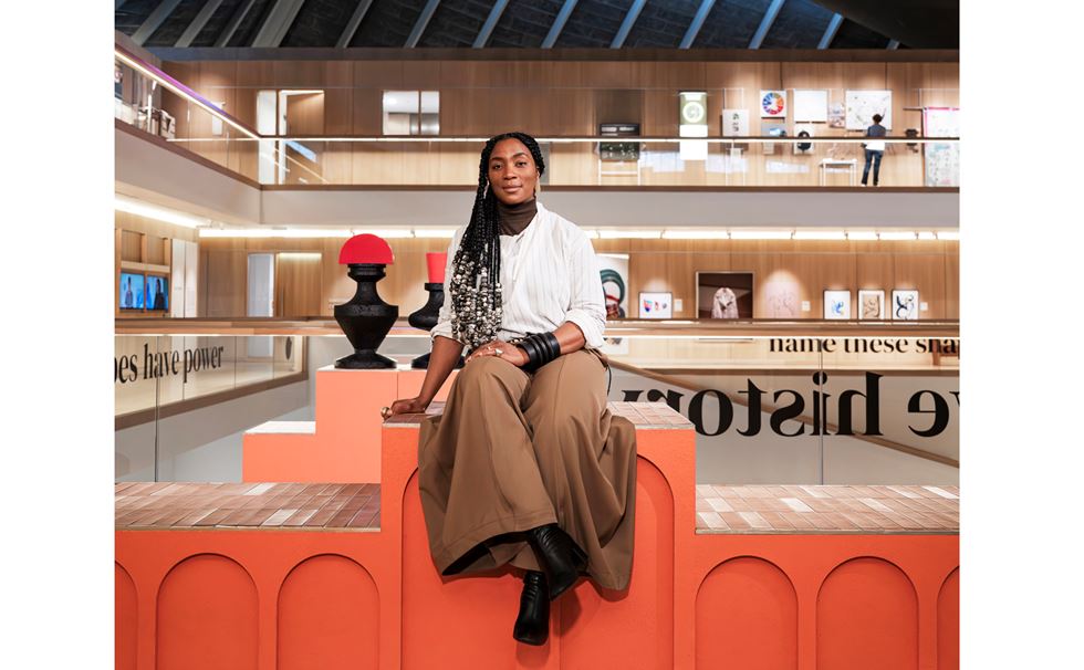 Simone Kitchen sitting on a sculptural orange platform in London's Design Museum.