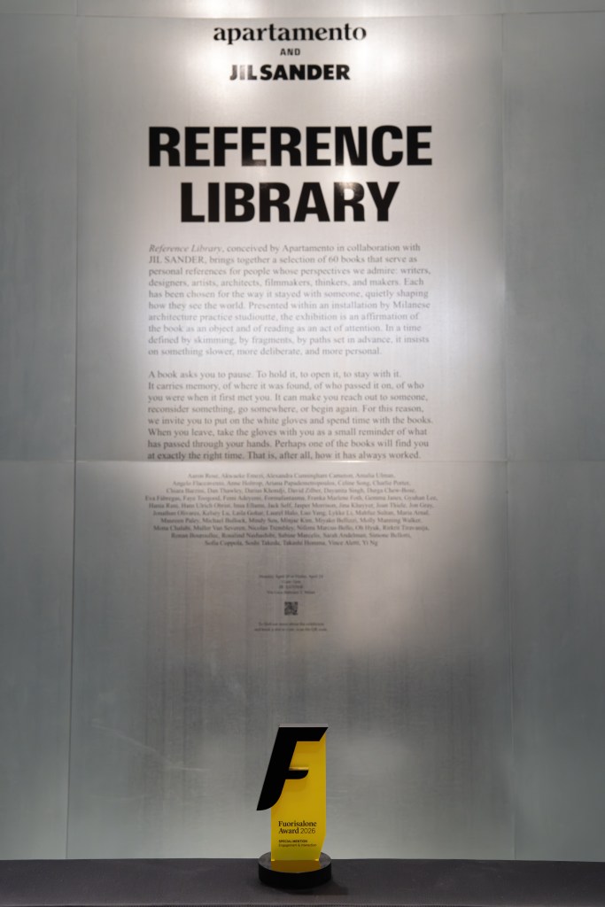 A tall panel with printed text, "REFERENCE LIBRARY," and "apartamento and JILSANDER" at the top of the panel, with a yellow Fuorisalone Award sitting at the bottom. 