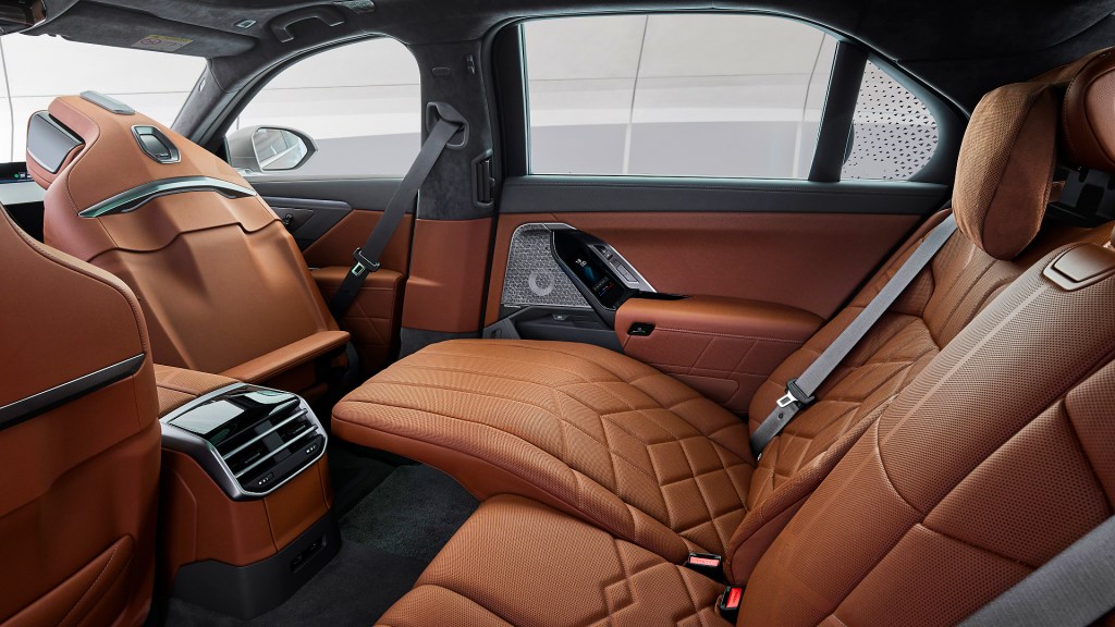 The back row of seats inside a BMW 7 series, shot from the side door, showing a deep recline.