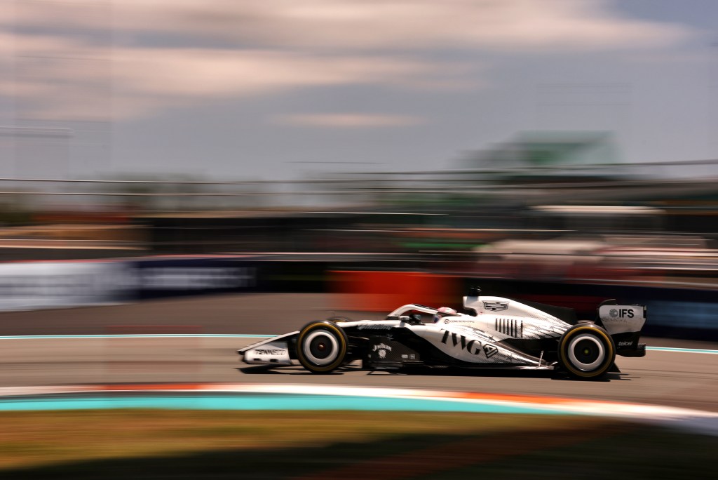 A Cadillac team car racing on a track with a blurry background.
