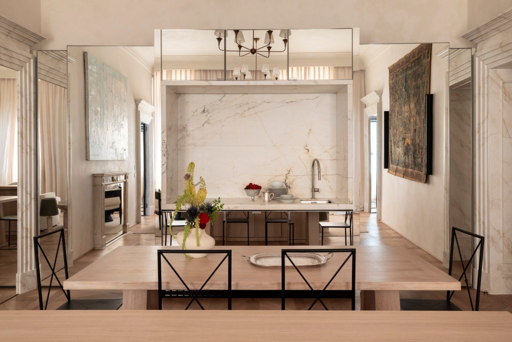 The kitchen as Casa Naman with mirrors, a large tapestry on the wall and minimal furnishings and fixtures.