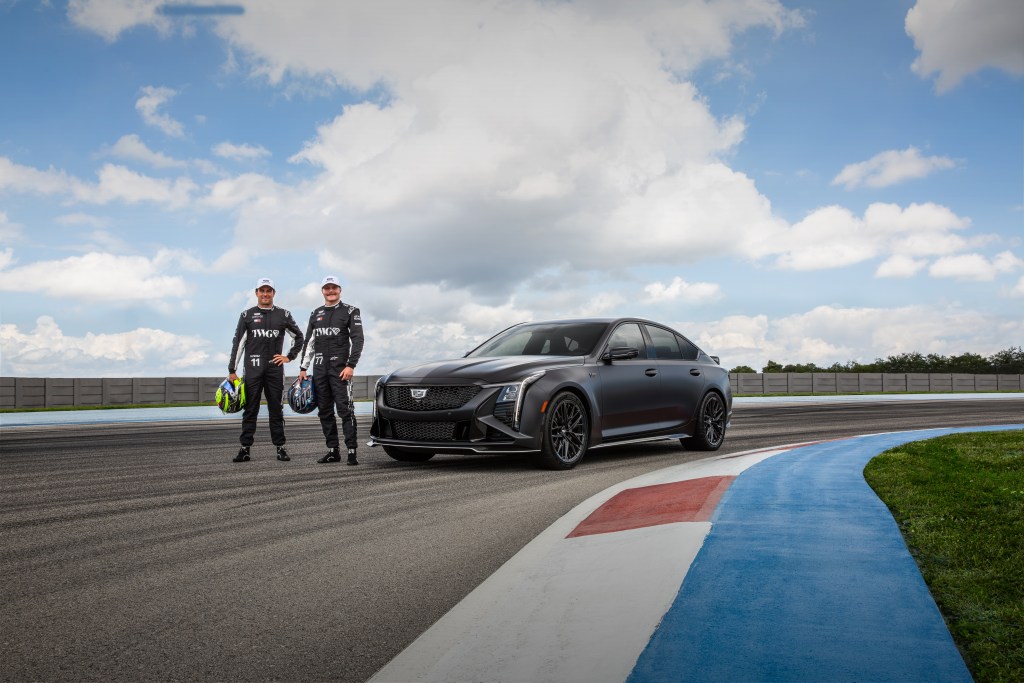 Two Cadillac F1 drivers standing next to the new CT5 V Blackwing F1 Collector Series on the Miami racetrack.