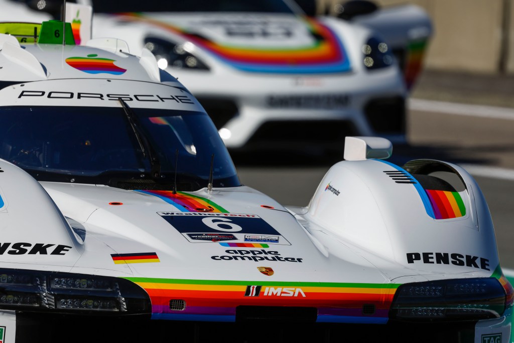 A detail of the humped body of a Porsche racecar with vintage Apple Computer graphics.