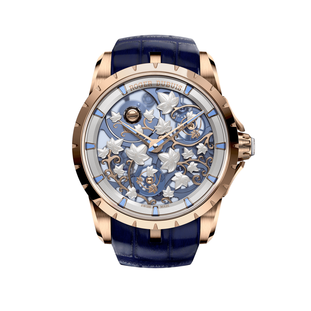 A front-on view of a blue, white and gold Roger Dubuis watch with ornate leaves and curling vines made of gold.