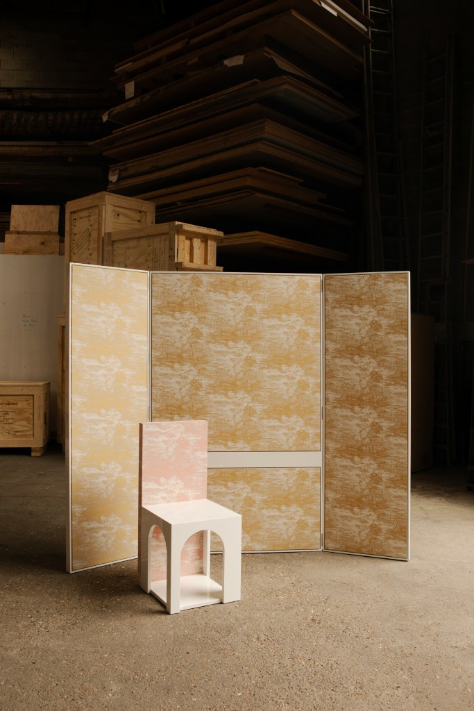 A room divider and a pink chair by Francesco Balzano, with a dark warehouse space in the background.