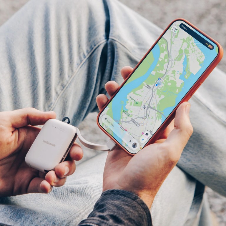 A person is holding Twelve South's PowerClip, which is connected to a phone