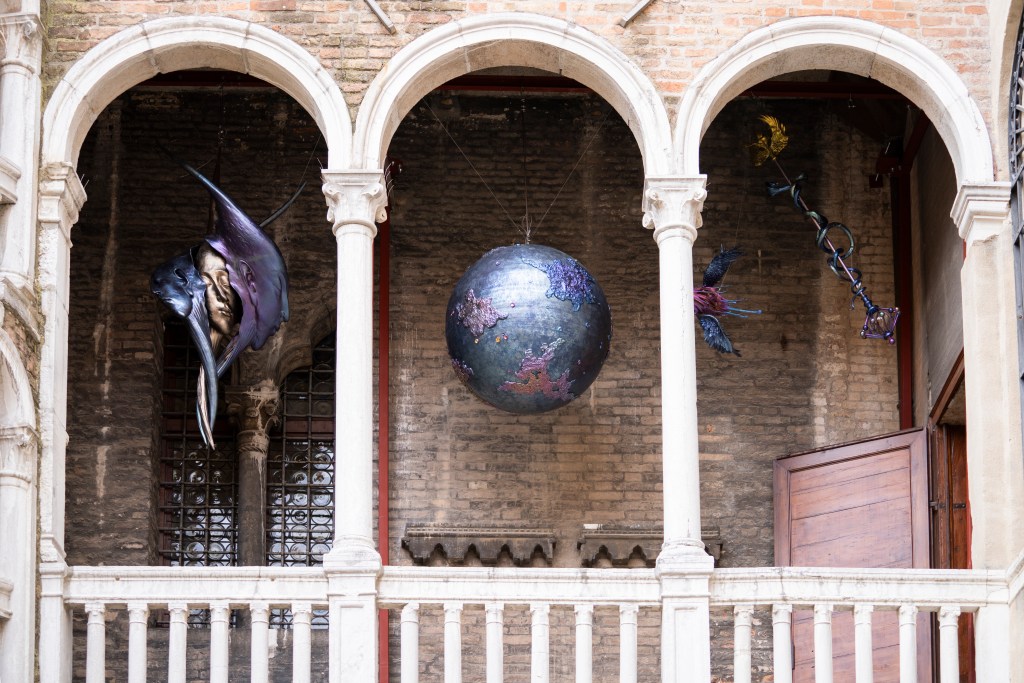 Three exterior archways at Bovolo Tower with three hanging sculptures by Wallace Cahn.