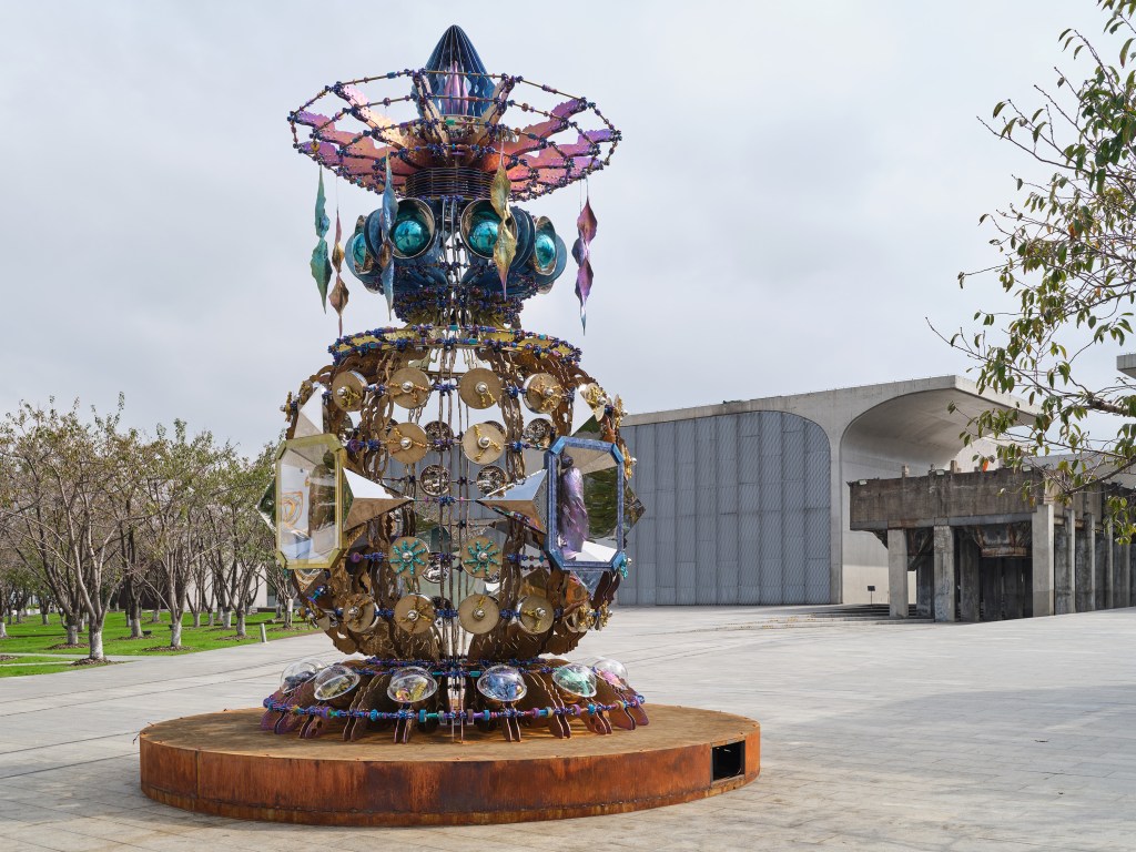 A pulled back shot of Birth Sculpture, part of the Vessels of Other Worlds exhibit, outside at the Long Museum.