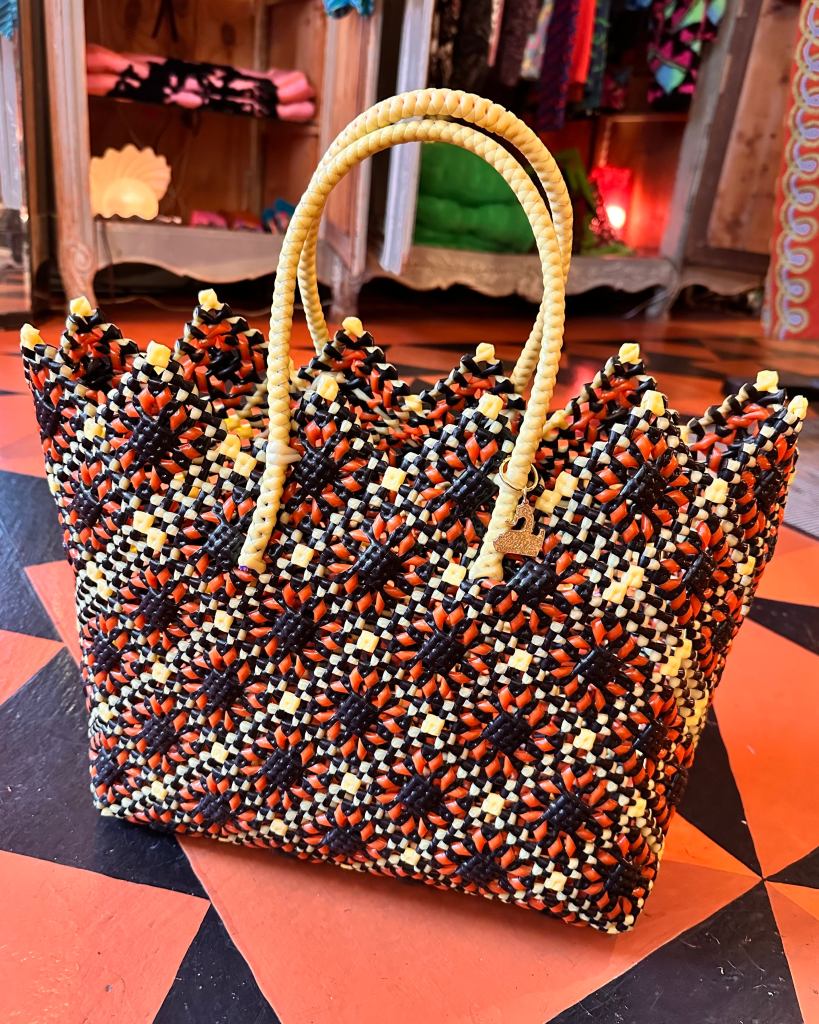 A tote bag with a sunflower motif in yellow, red and black