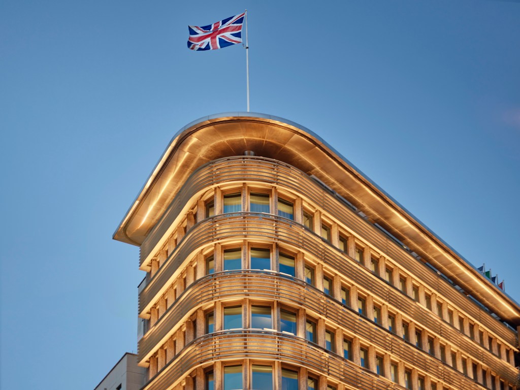 The exterior of 45 Park Lane, looking up from the street level, with a United Kingdom flag at the top of the roof.