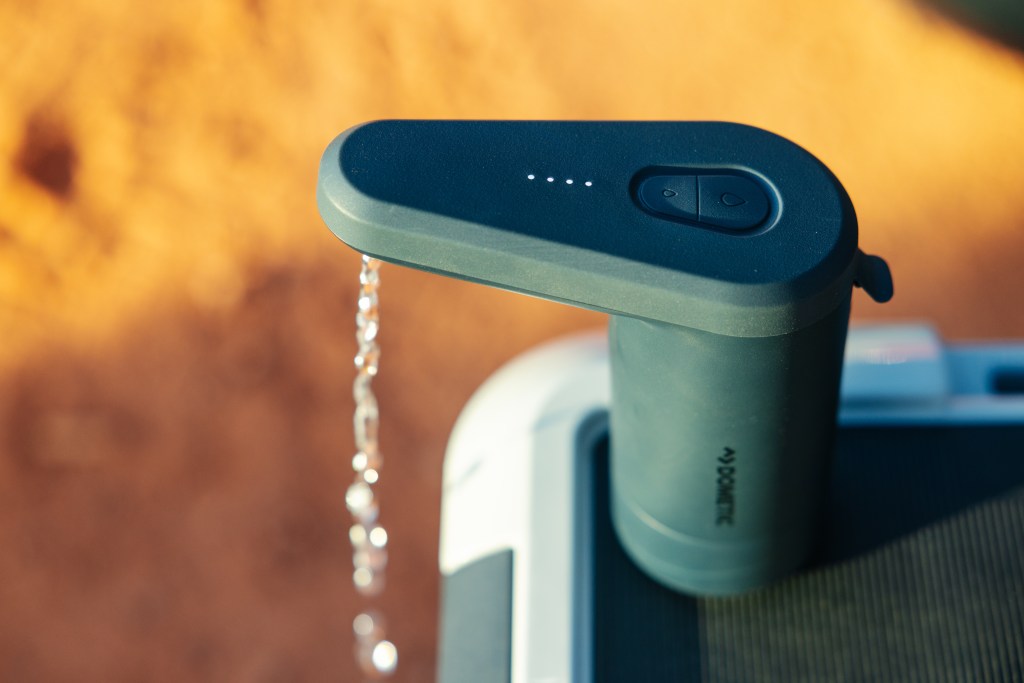 A detail of a green Recon faucet with water dripping out. 