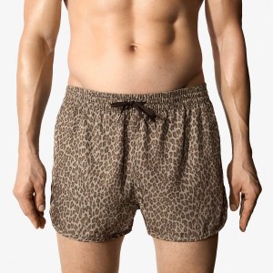 A model wears CDLP's swim shorts in mocca leopard