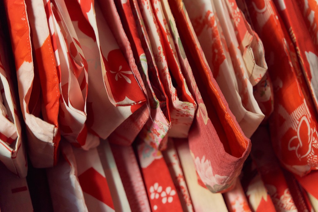 A detail of a collection of red Nancy Martin kimonos.