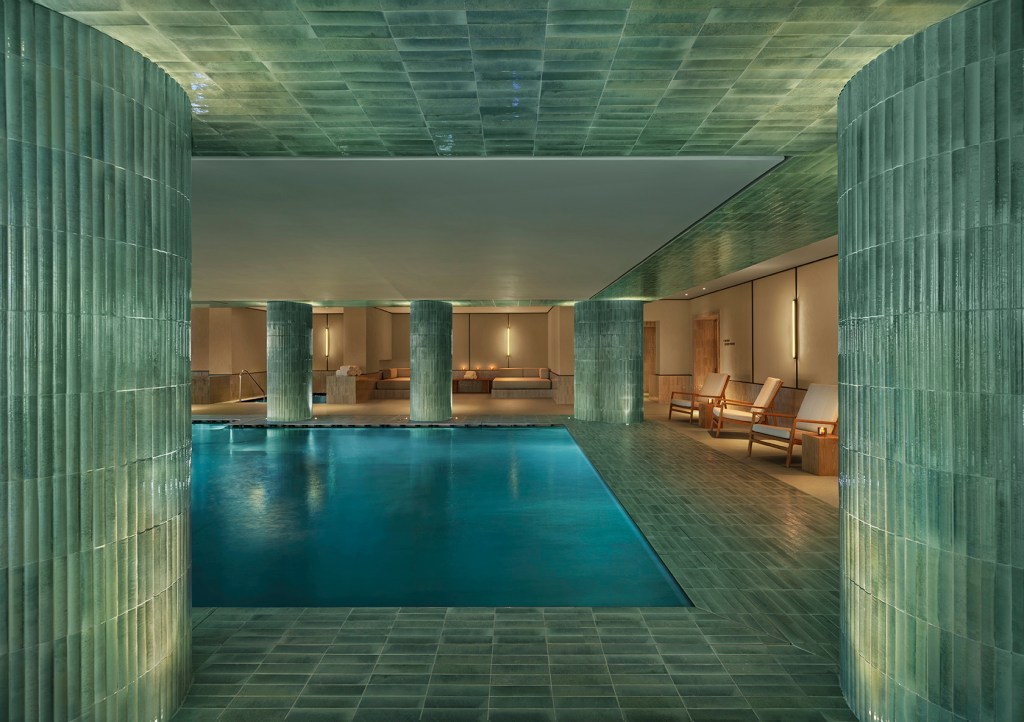 The indoor pool at Lake Como EDITION with green tiles covering the room.