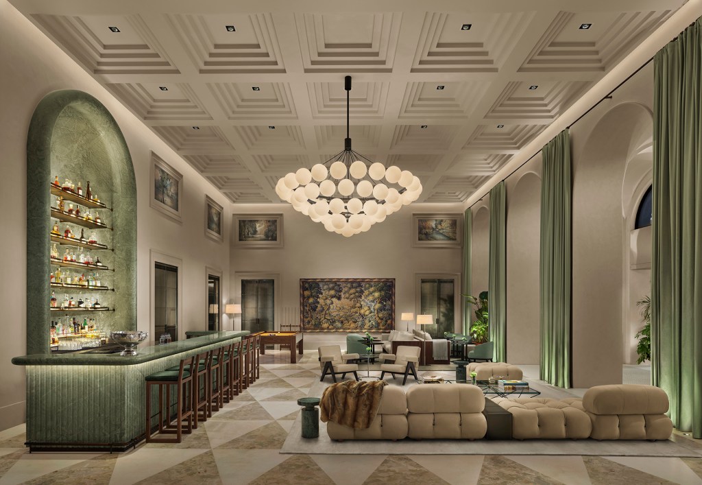 The lobby at Lake Como EDITION with tall ceilings, green fabric panels on the wall and a large chandelier hanging from above.