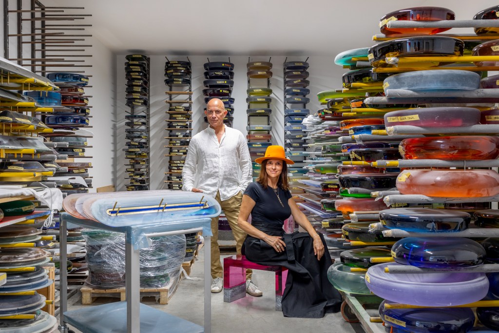 Aurel K. Basedow and Draga Obradovic in their studio surrounded by stacks of their colorful designs.