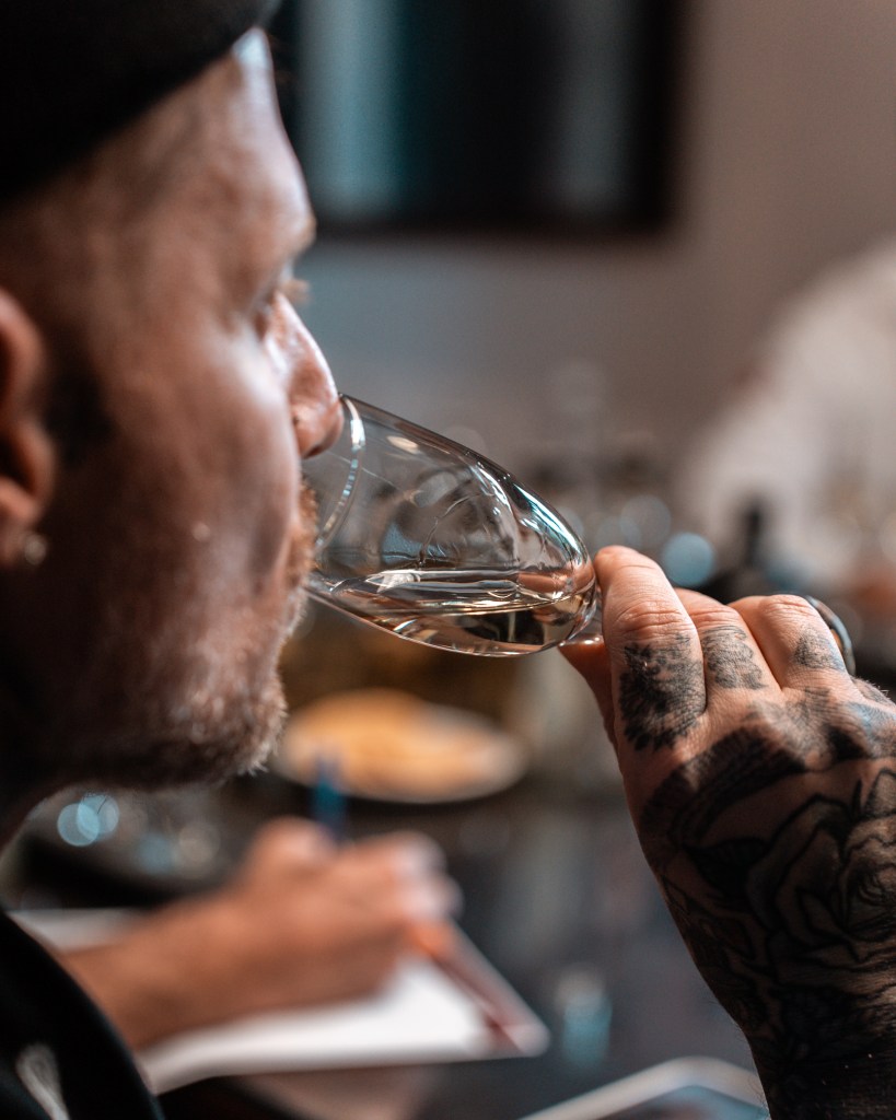 A closeup view of chef Michael Voltaggio tasting from a glass of tequila.