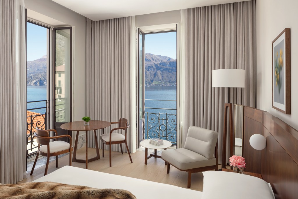 A guest room at Lake Como EDITION Hotel with views of the mountain and lake outside the window.