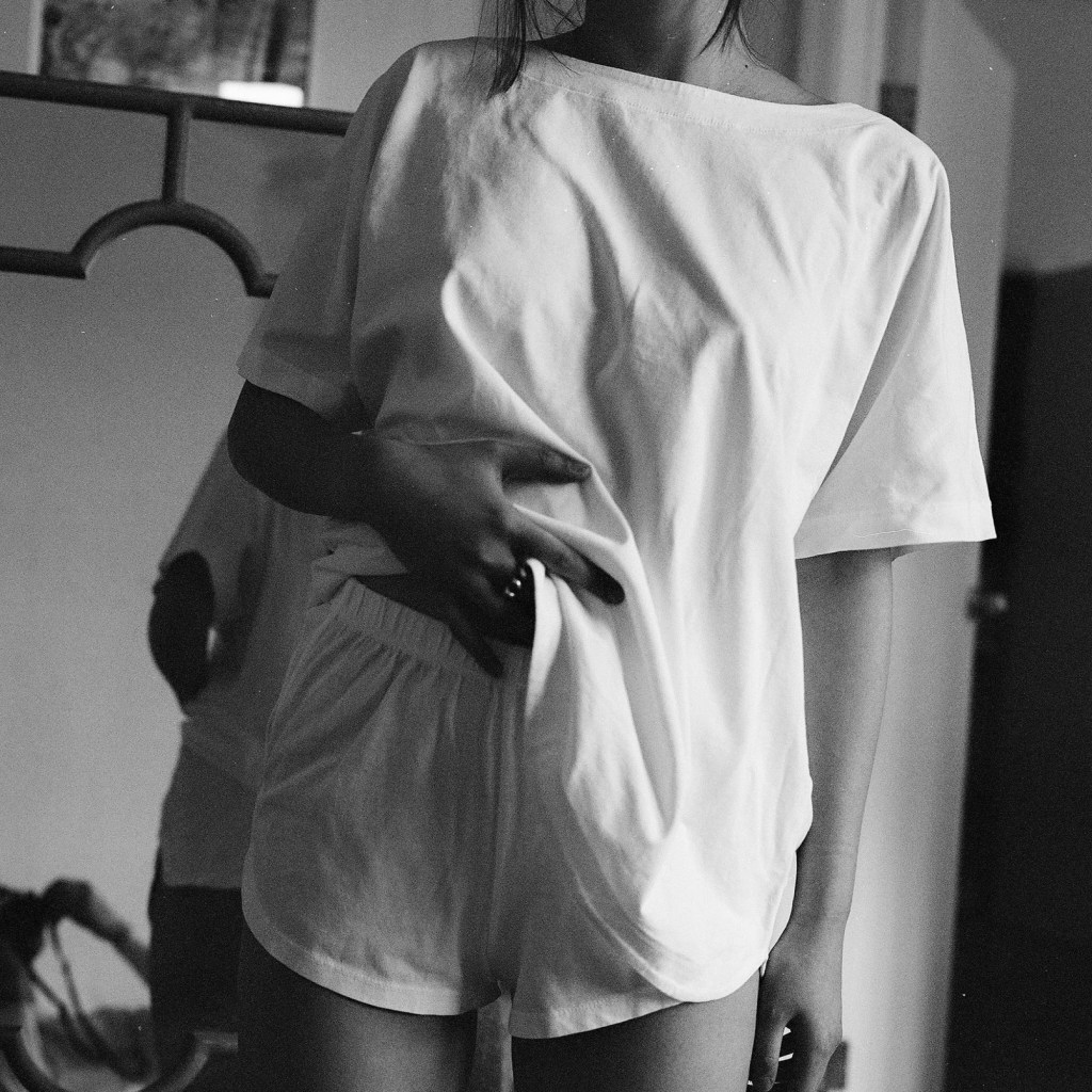 A woman wears the top and bottom of Kent's sleep tee set