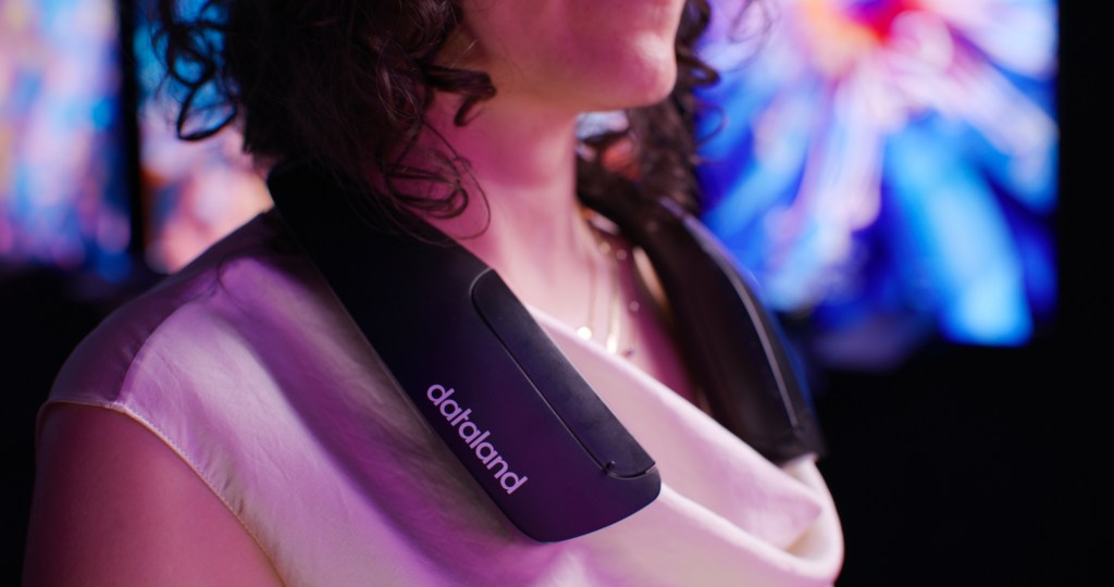 A detail of a person wearing a custom Refik Anadol Studio device around her neck designed to release scents during viewing of the exhibition at Dataland.