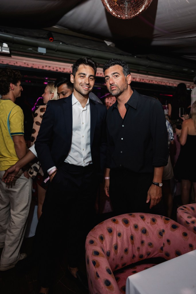 Milo Frank and John Terzian standing together with people milling about in the background of their Montauk Delilah pop-up.