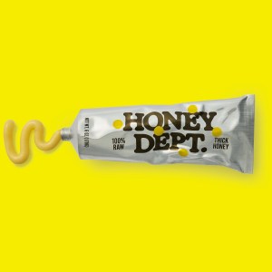 A tube of Honey Department's thick honey, with some honey squeezed out