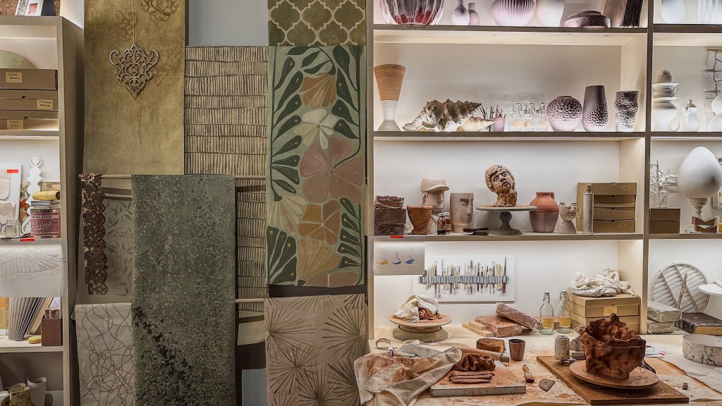 A detail of a shelf of various fabrics, ceramics and handmaking tools.