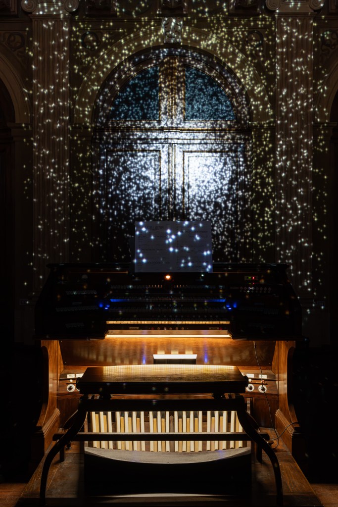 An organ with projected images in front of it.