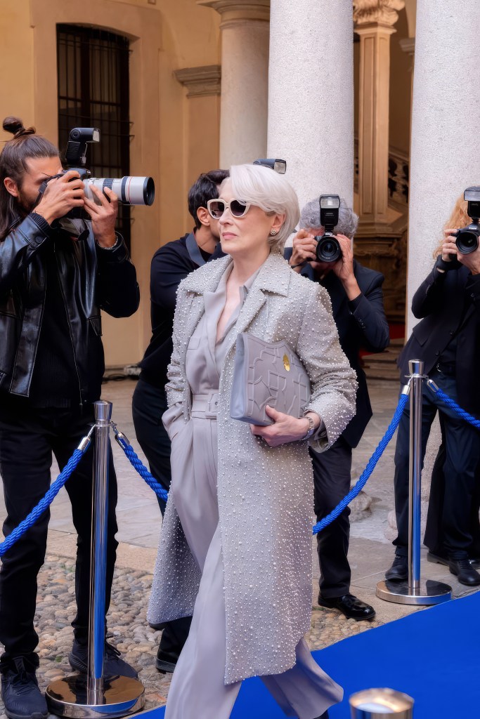 A film still from The Devil Wears Prada 2 with Meryl Streep wearing an all gray suit and carrying a Dellaluna bag.