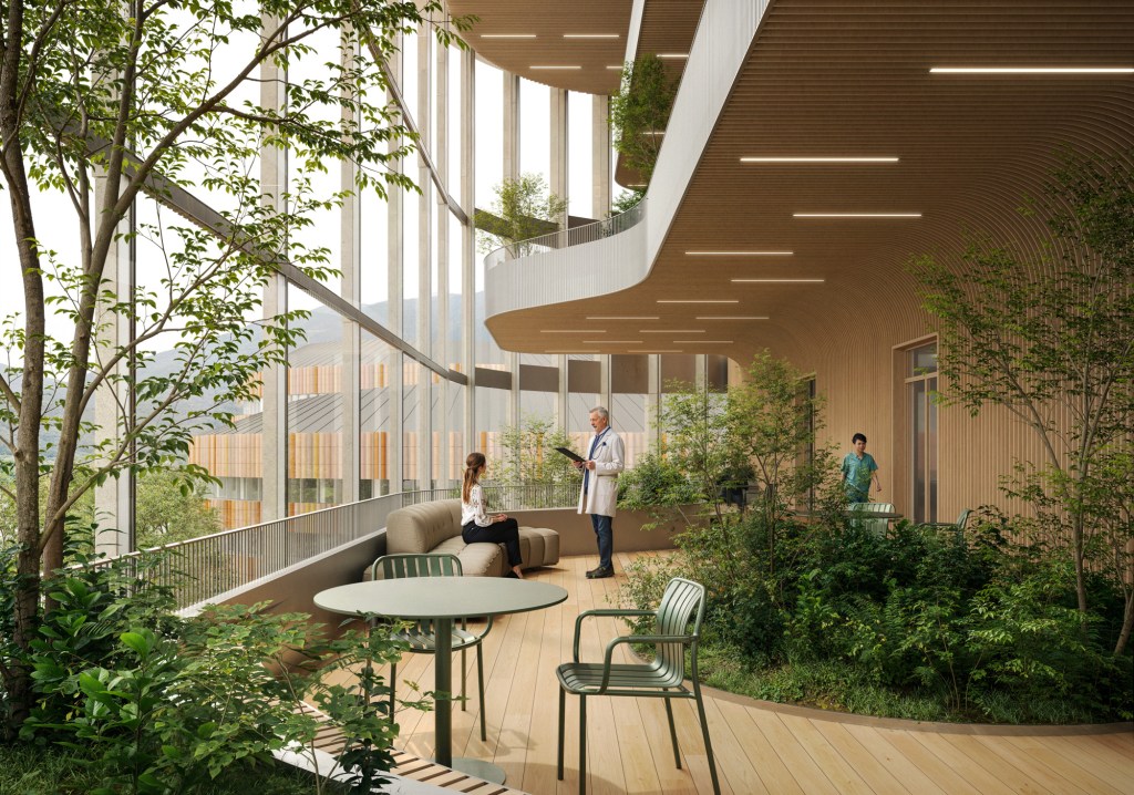 A large multi-story room with tall windows, plants and trees, and people talking on the ground level.