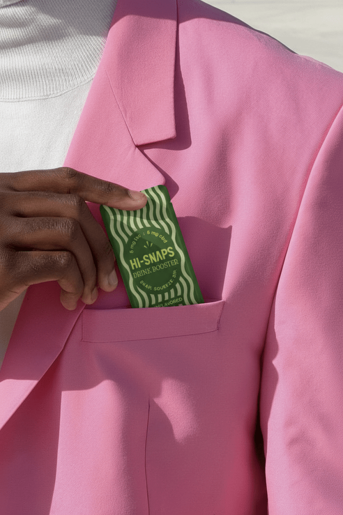 A hand reaches into a pink blazer's chest pocket to touch a green Hi-Snap.