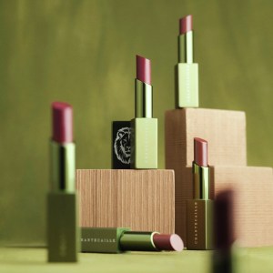 Assorted Chantecaille lip sticks, opened, sitting on blocks and a table