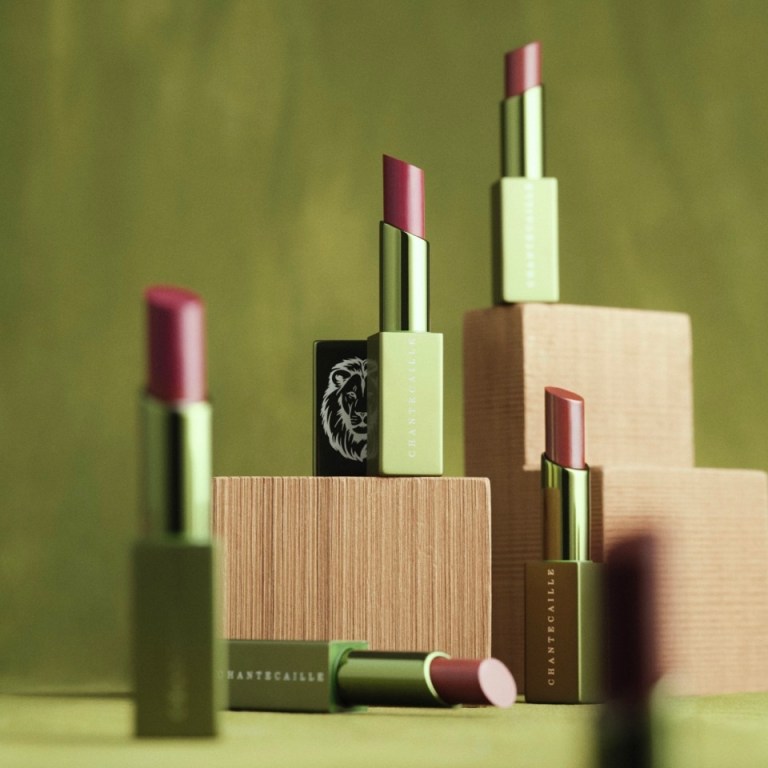 Assorted Chantecaille lip sticks, opened, sitting on blocks and a table