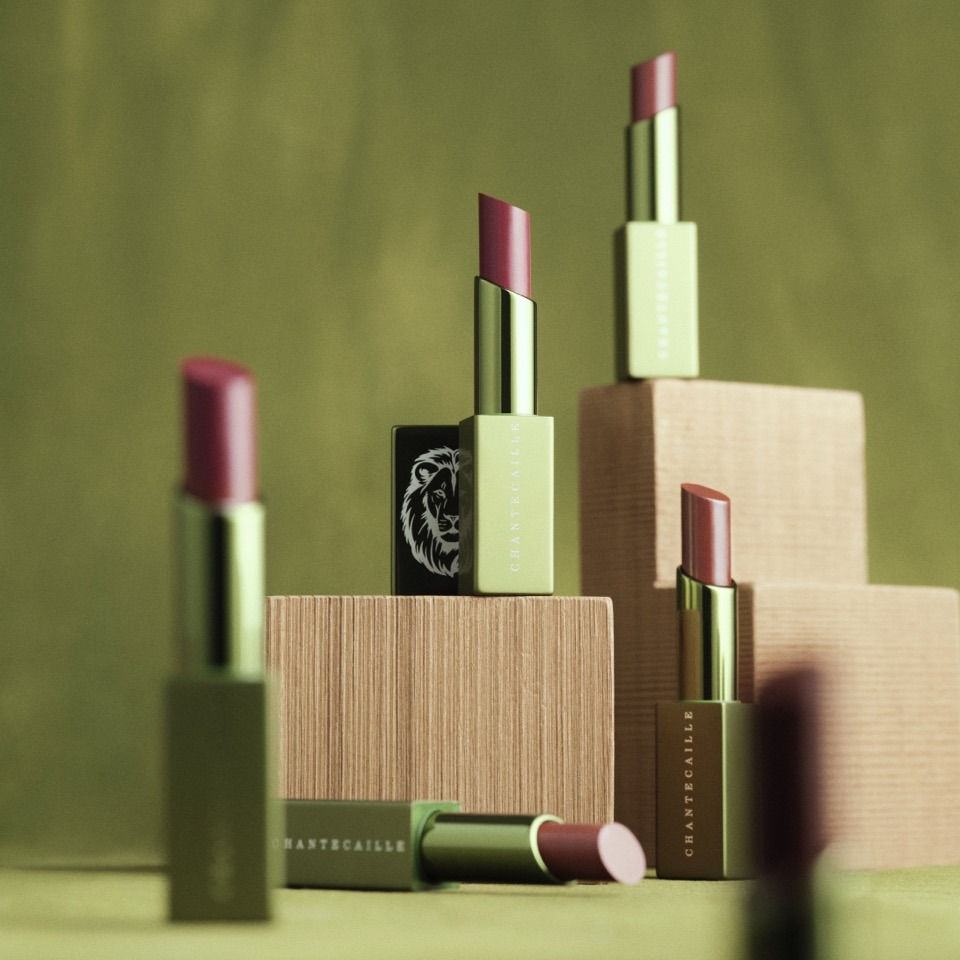 Assorted Chantecaille lip sticks, opened, sitting on blocks and a table