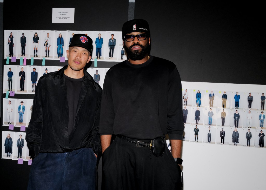 Dao-Yi Chow and Maxwell Osborne stand next to each other in front of a dark wall covered in model photos.