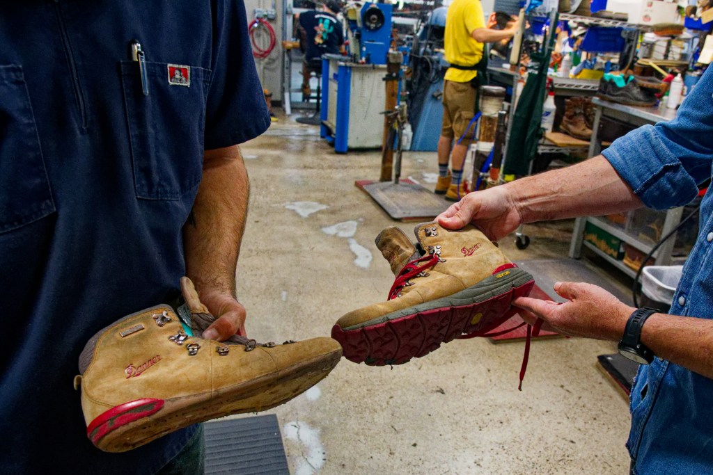 Two sets of hands, each holding a Danner boot, comparing an old, worn-down boot with a repaired boot.