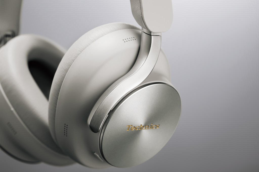 A detail of a pair of Technics with silver details on a gray background.