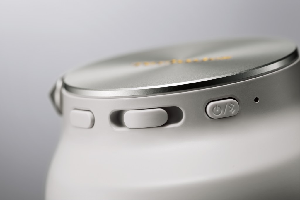 A detail of the side switch on a pair of Technics headphones on a light gray background.