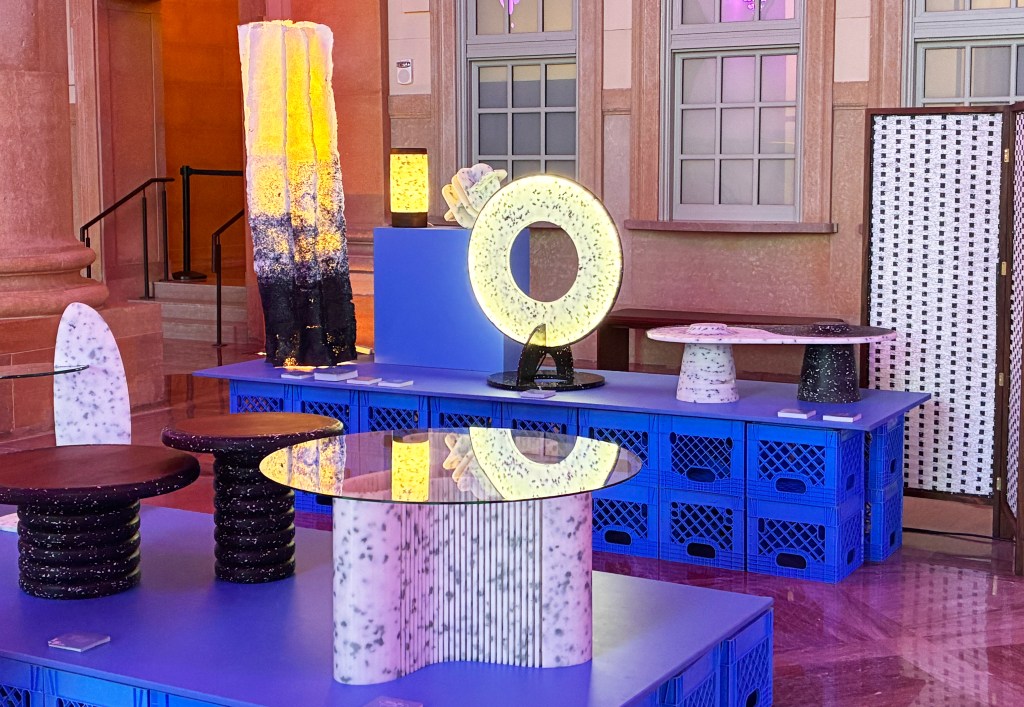 A display of recycled plastic furniture and lighting displayed on bright blue plastic milk crates.