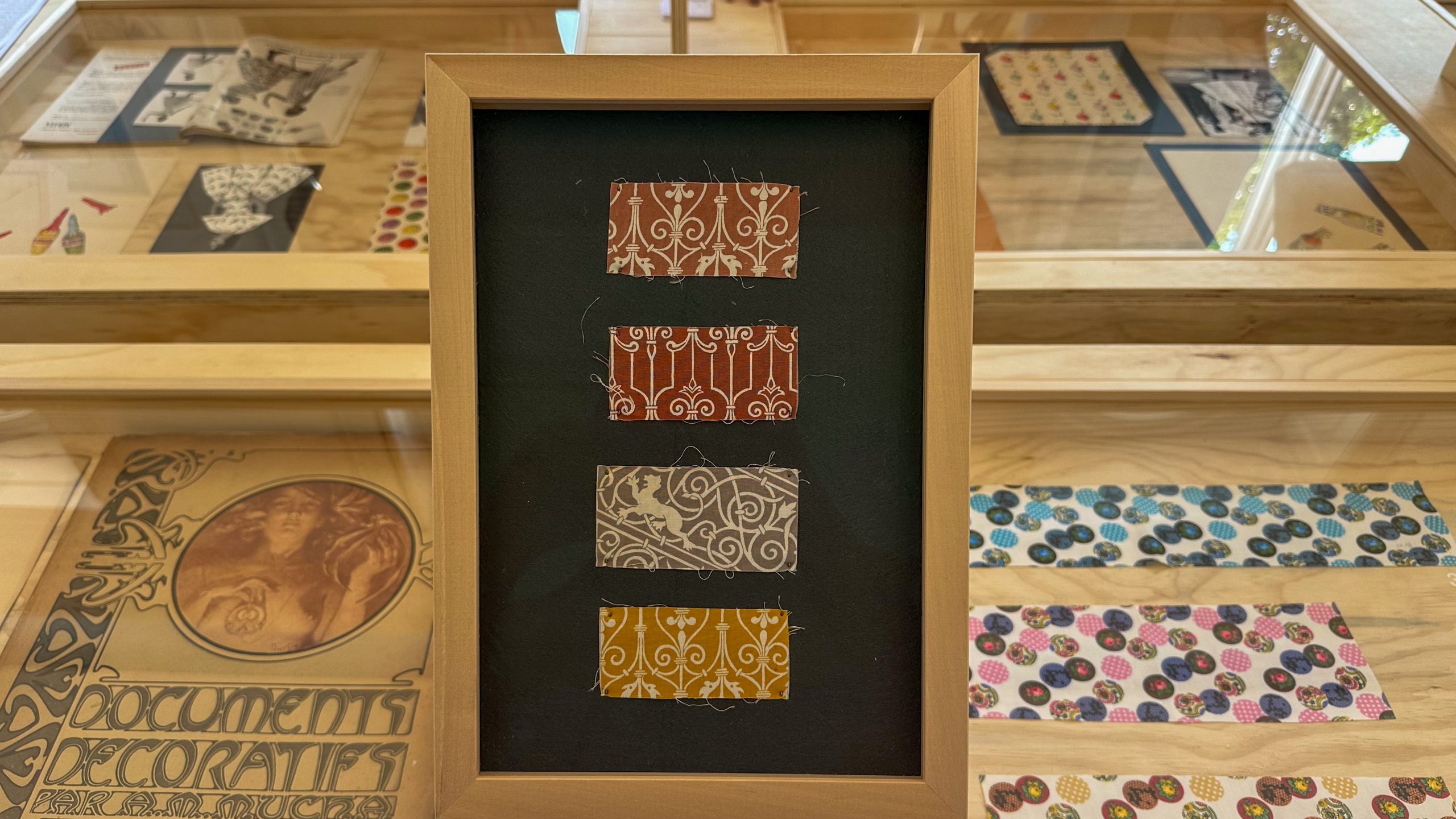 A collection of textiles at the Archivio Carla Badiali on a wood surface.