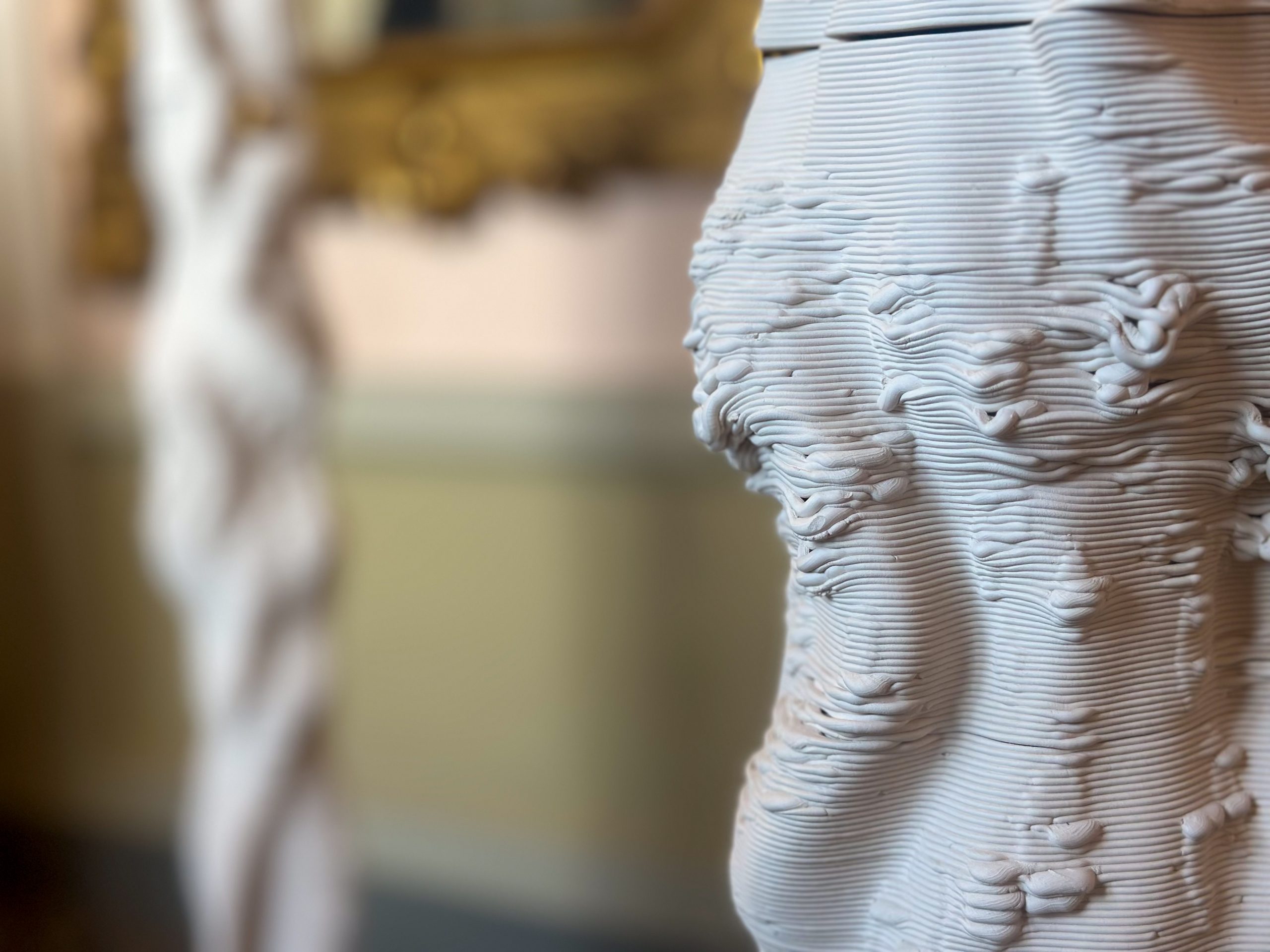 A detail of a white sculpture showing a texture that looks like wrapped white string.