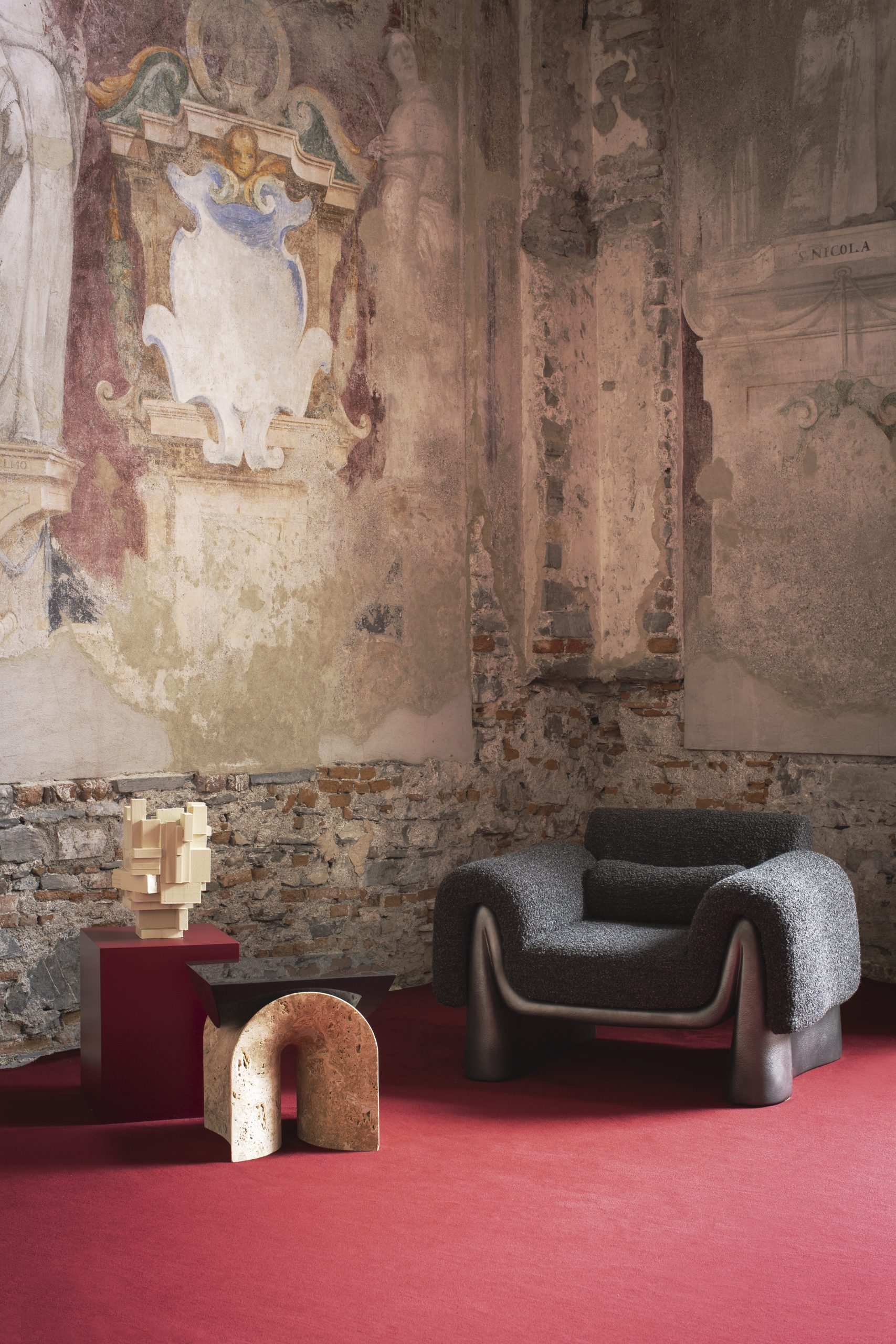 A room with red carpet and sculptural furniture displayed.