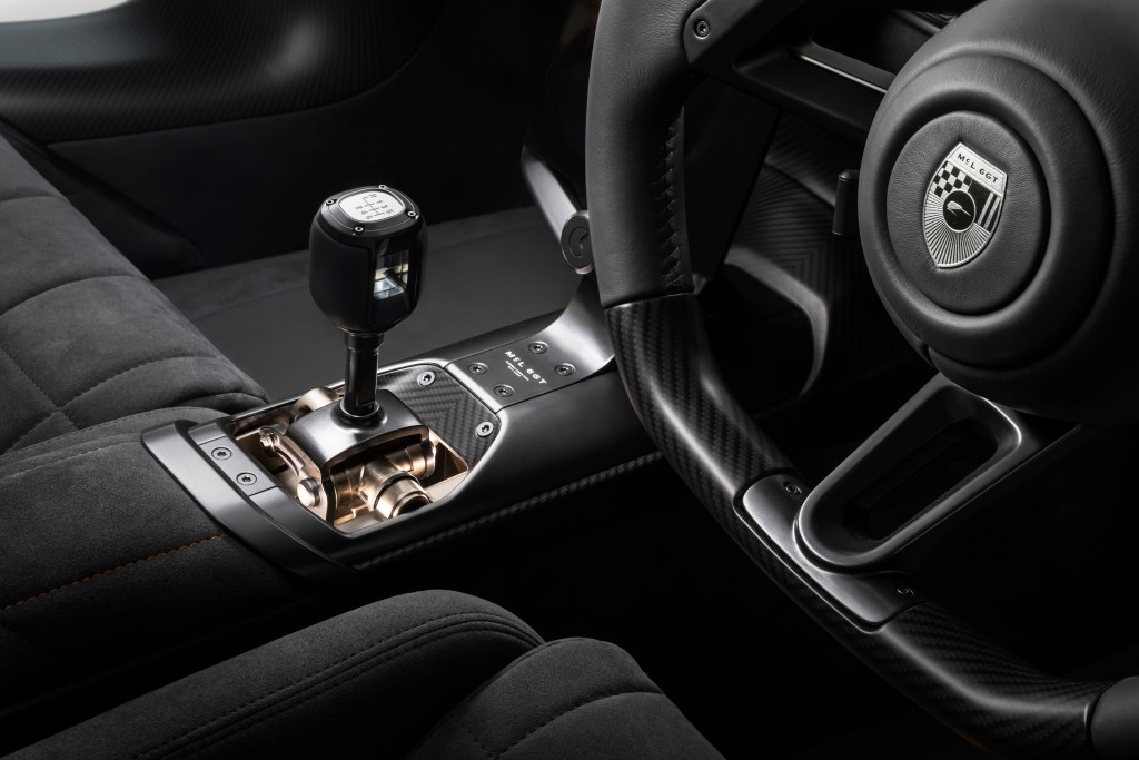 A detail of the steering wheel, gear shifter and front seats in the McLaren McL 6GT.
