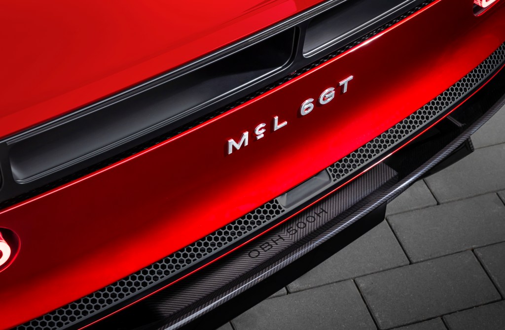 The rear bumper of a red McLaren McL 6GT. shot at an angle.